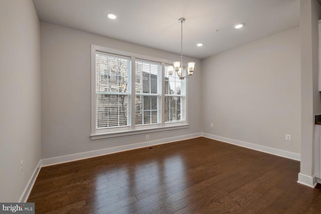 unfurnished dining area featuring dark hardwood / wood-style flooring and a chandelier