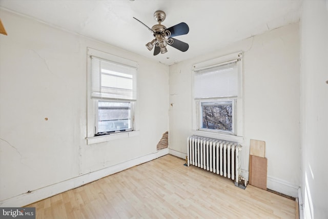 spare room with radiator, ceiling fan, and light hardwood / wood-style floors