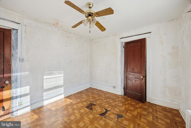 unfurnished room with dark parquet floors and ceiling fan