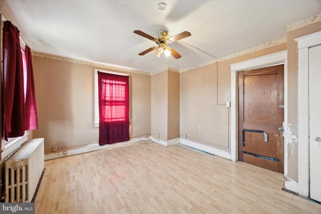 interior space with ceiling fan, light hardwood / wood-style floors, and radiator heating unit