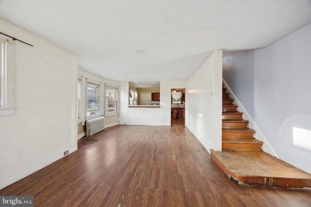 unfurnished living room with hardwood / wood-style floors and radiator heating unit