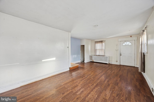 foyer entrance with radiator heating unit and dark hardwood / wood-style floors