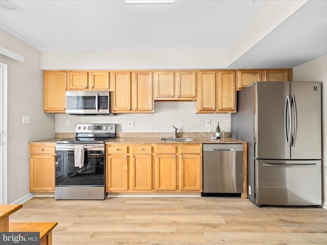 kitchen featuring sink, stainless steel appliances, light brown cabinets, and light wood-type flooring