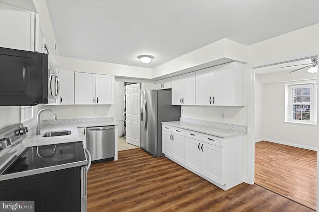 kitchen with ceiling fan, sink, stainless steel appliances, dark hardwood / wood-style floors, and white cabinets