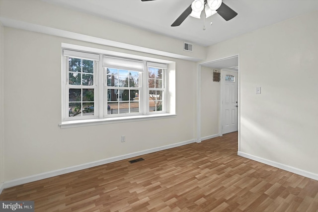 empty room with ceiling fan and light hardwood / wood-style floors