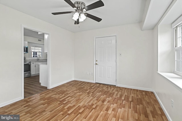 spare room featuring ceiling fan, sink, and hardwood / wood-style flooring