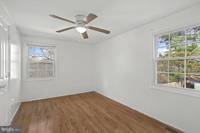 spare room featuring hardwood / wood-style flooring, a wealth of natural light, and ceiling fan