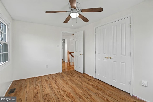 unfurnished bedroom with ceiling fan, a closet, and light hardwood / wood-style flooring