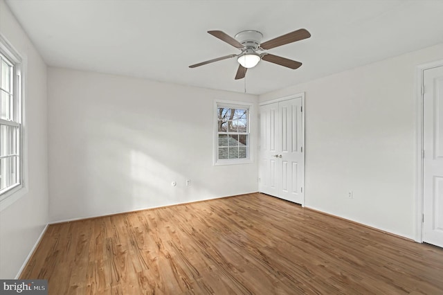 unfurnished room featuring hardwood / wood-style floors, plenty of natural light, and ceiling fan