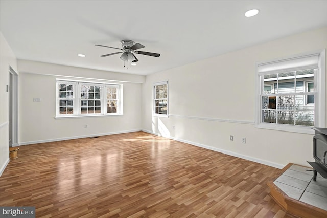 unfurnished living room with hardwood / wood-style flooring, ceiling fan, and a healthy amount of sunlight