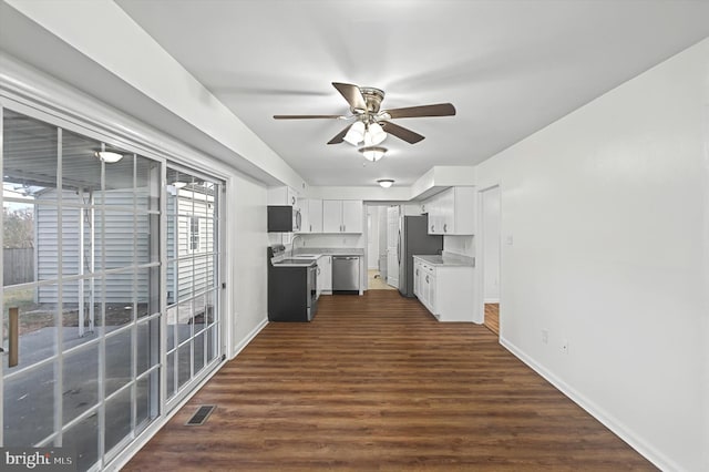 kitchen with stainless steel appliances, ceiling fan, sink, dark hardwood / wood-style floors, and white cabinetry