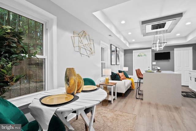 interior space featuring a raised ceiling and light hardwood / wood-style flooring