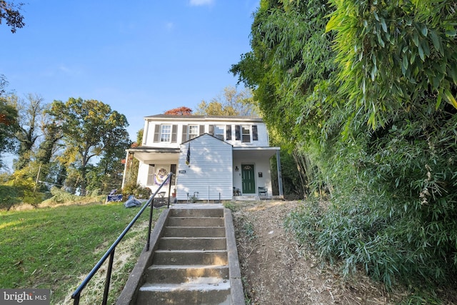 view of front of house featuring covered porch and a front lawn