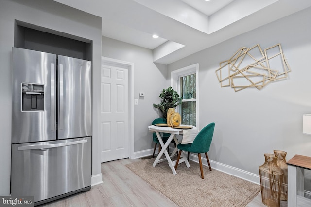 interior space featuring stainless steel fridge and light hardwood / wood-style floors