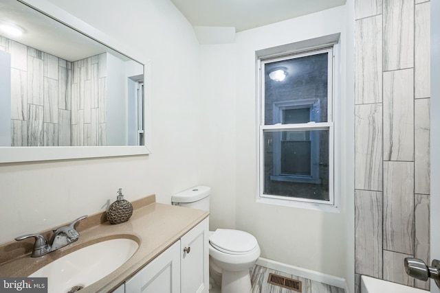 bathroom with a shower, vanity, and toilet