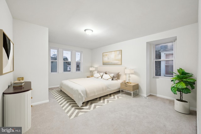 bedroom with light carpet and multiple windows