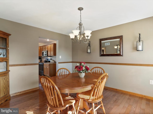 dining area with dark wood-type flooring and a chandelier