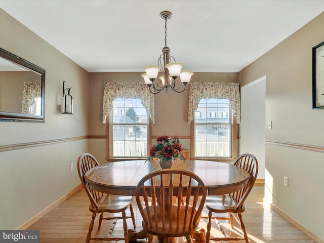 dining space featuring light hardwood / wood-style floors and an inviting chandelier