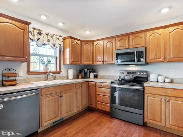 kitchen featuring wood-type flooring, appliances with stainless steel finishes, and sink