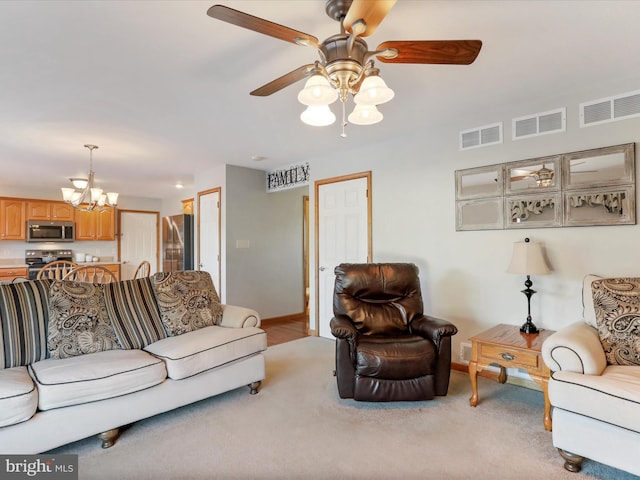 living room featuring light carpet and ceiling fan with notable chandelier