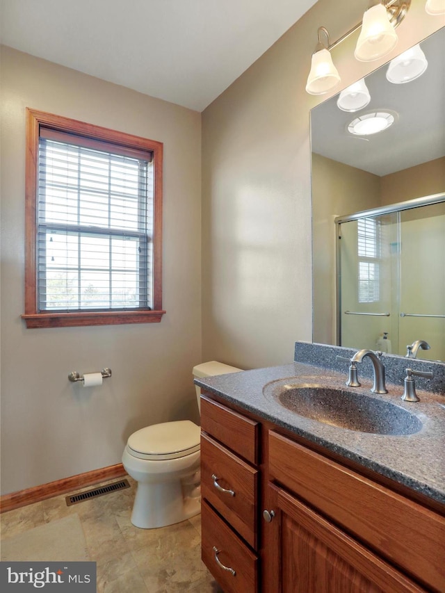 bathroom with vanity, toilet, and an enclosed shower