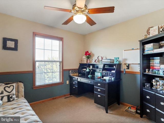 carpeted office space with ceiling fan