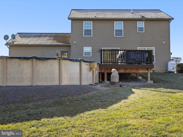 back of house with a wooden deck and a lawn