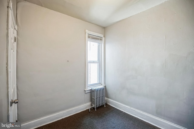 carpeted spare room with radiator heating unit