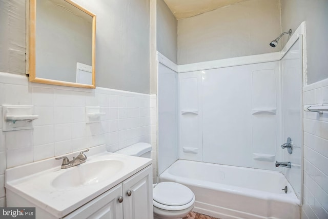 full bathroom with shower / bathing tub combination, vanity, toilet, and tile walls