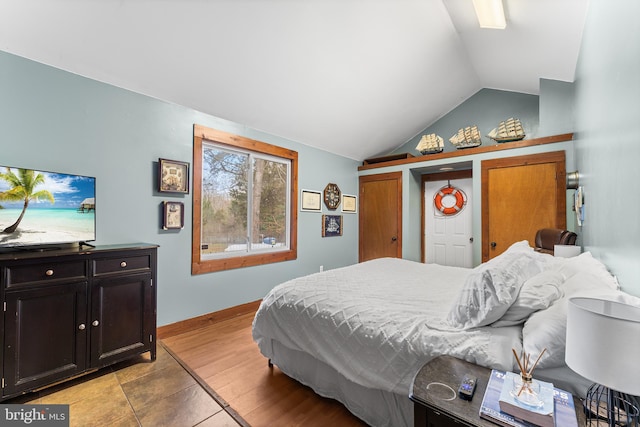 bedroom with light wood-type flooring and vaulted ceiling