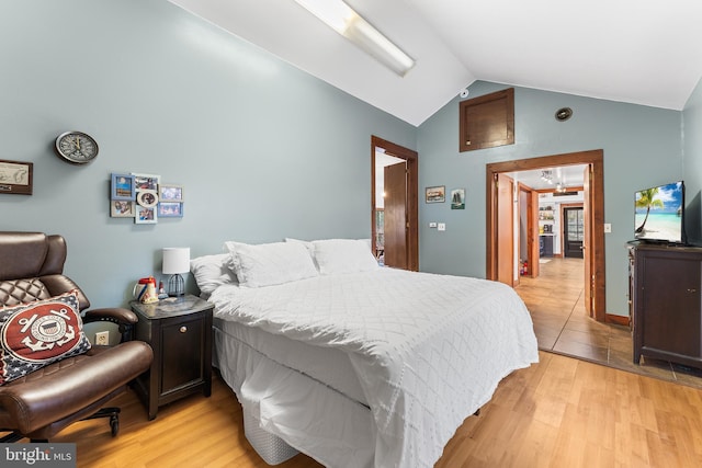 bedroom featuring light hardwood / wood-style floors and lofted ceiling