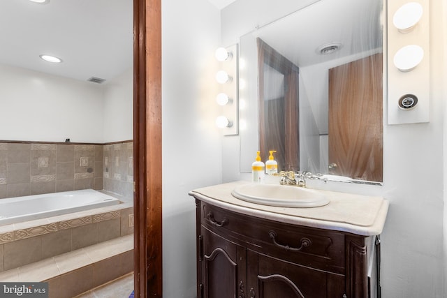 bathroom with vanity and a relaxing tiled tub