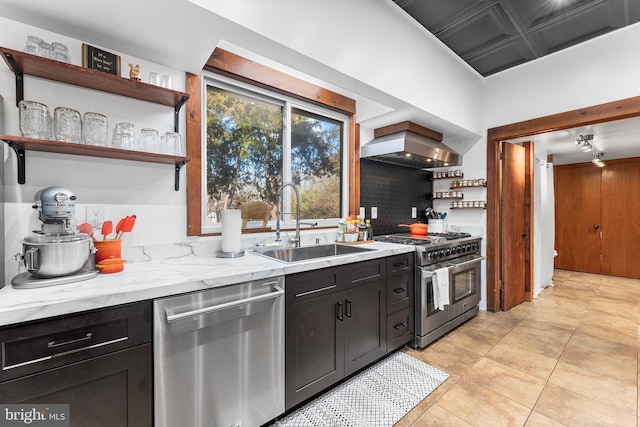 kitchen with light stone countertops, appliances with stainless steel finishes, backsplash, sink, and range hood