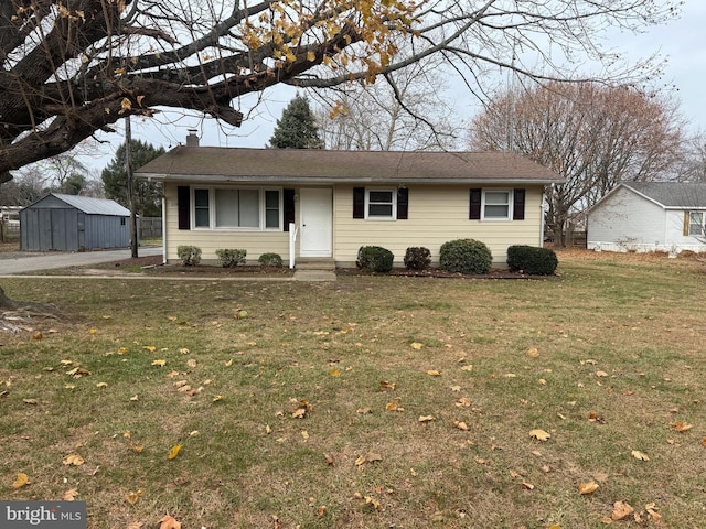 ranch-style home featuring an outbuilding and a front lawn