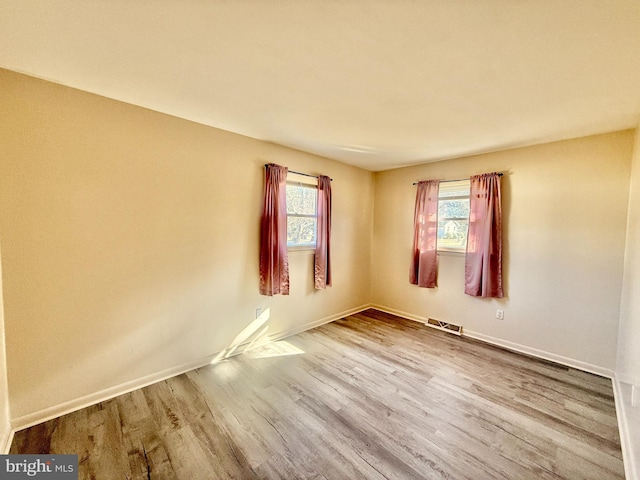 unfurnished room with plenty of natural light and light hardwood / wood-style flooring