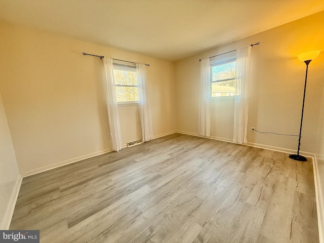 unfurnished room featuring a wealth of natural light and hardwood / wood-style flooring