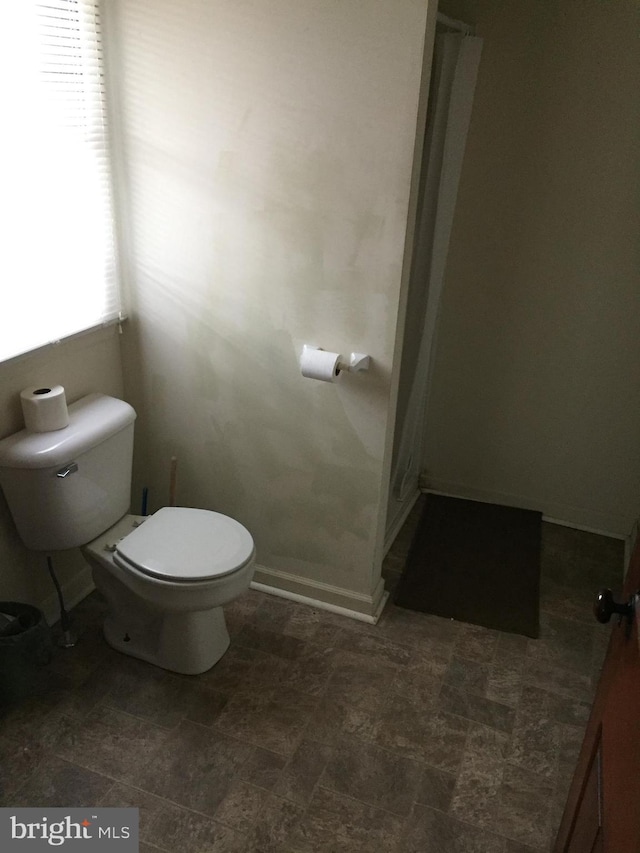 bathroom featuring a wealth of natural light and toilet