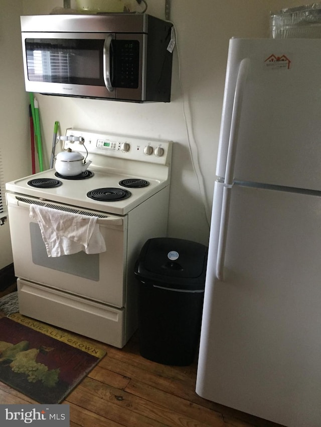 kitchen with white appliances and dark wood-type flooring