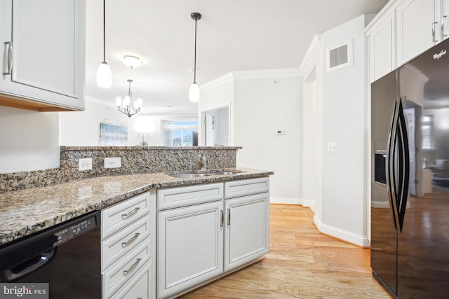 kitchen featuring black appliances, sink, light stone countertops, light hardwood / wood-style floors, and white cabinetry