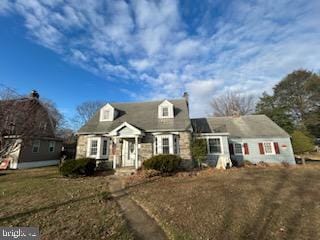 cape cod-style house with a front yard