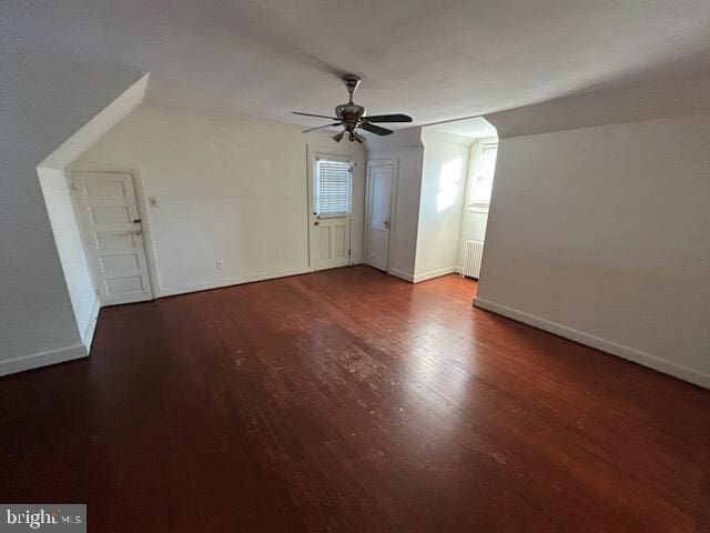 bonus room with ceiling fan, dark hardwood / wood-style flooring, and radiator