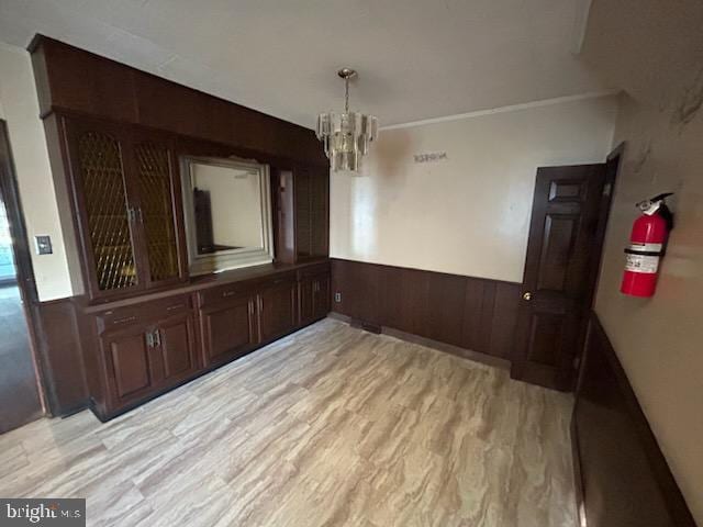 unfurnished dining area featuring light hardwood / wood-style flooring and a notable chandelier