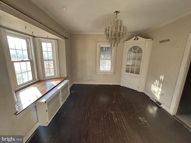 unfurnished dining area with radiator heating unit, dark hardwood / wood-style flooring, ornamental molding, and an inviting chandelier