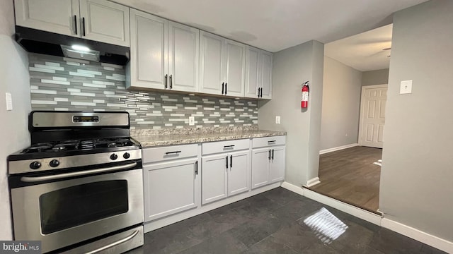 kitchen with backsplash, gas range, light stone counters, and white cabinets