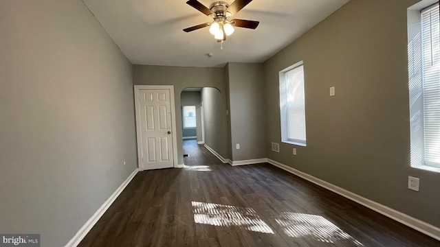 unfurnished room with ceiling fan, plenty of natural light, and dark hardwood / wood-style floors