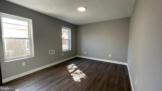 unfurnished room with dark hardwood / wood-style flooring