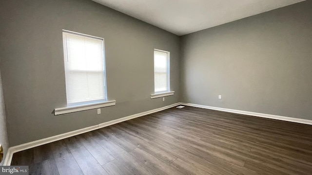 empty room with dark wood-type flooring