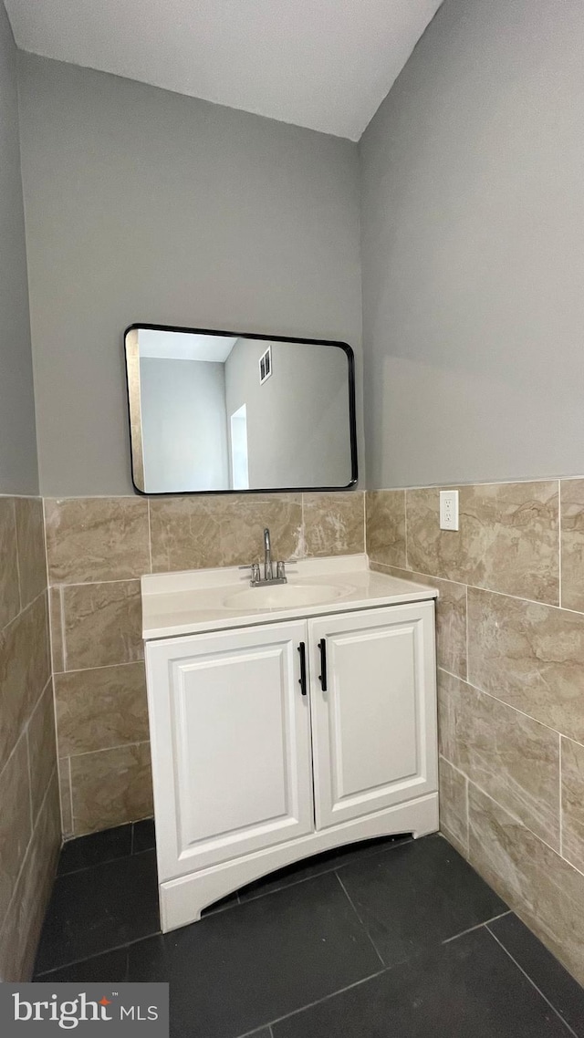 bathroom featuring vanity, tile patterned floors, and tile walls