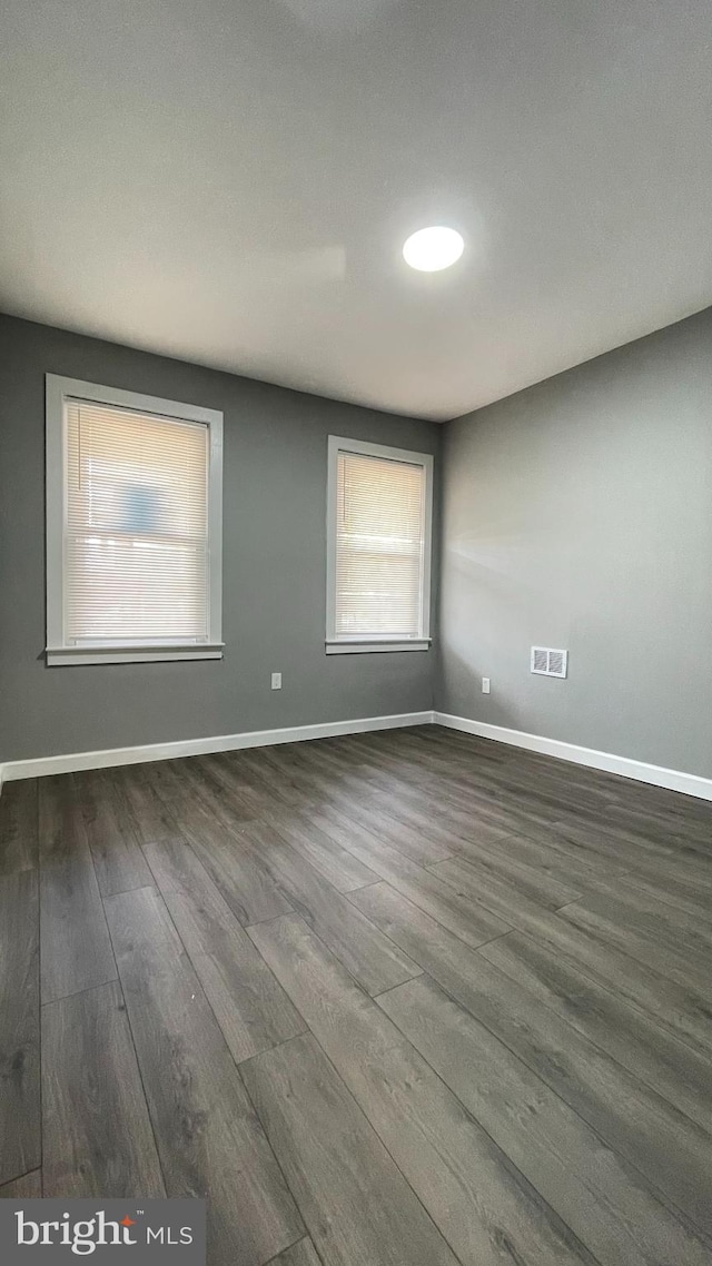 empty room with dark hardwood / wood-style floors