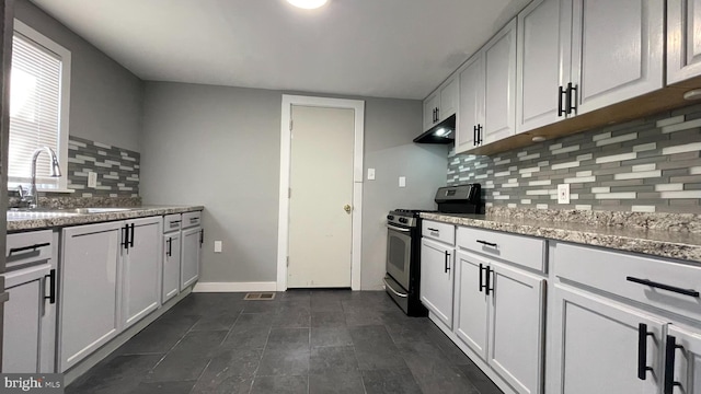 kitchen featuring light stone countertops, sink, tasteful backsplash, white cabinets, and stainless steel range with gas stovetop